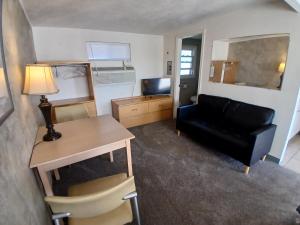 a living room with a desk and a couch and a table at Silver Lakes Inn in Hayden