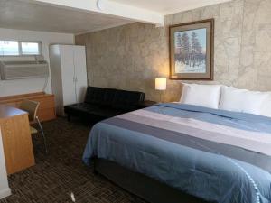 a hotel room with a bed and a chair at Silver Lakes Inn in Hayden