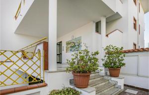 a building with three potted plants on the stairs at Bilo 2 in Alba Adriatica