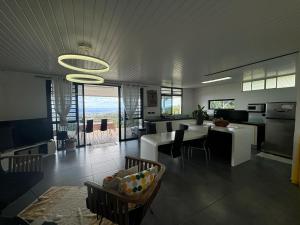 a kitchen and living room with a table and chairs at Airport Pamatai Room in Faaa