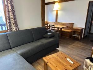 La Plagne TarentaiseLe Chalet De Montchavin - Bel appartement proche du centre MAE-4314的客厅里有一张沙发和一张桌子。