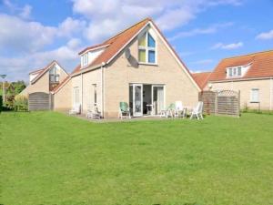a large house with a lawn in front of it at Bungalow in Breskens near the Beach in Breskens