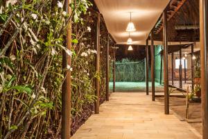 a corridor in a greenhouse with plants at Arena Carneiros Hotel by AFT in Tamandaré
