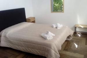 a bedroom with a white bed with towels on it at Casa Tinta in San Carlos de Bariloche