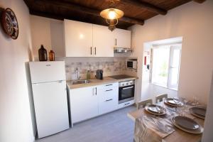 a kitchen with a white refrigerator and a table at A Casinha do Canto in Moura