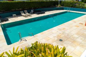 a swimming pool with two chairs and a table at Sunrise Penthouse in Tuncurry