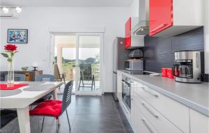 a kitchen with a table and a dining room at Nice Home In Valbandon With Jacuzzi in Valbandon
