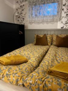 a bed with yellow sheets and pillows on it at Hoda Apartment - Cozy central apartment with free parking in Leknes