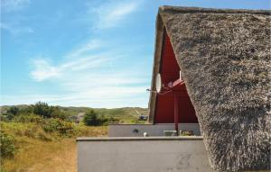 a house with a thatched roof on a field at Holiday Home Tingodden Iv in Hvide Sande