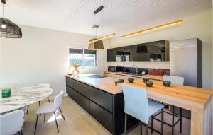 a kitchen with a counter and a table and chairs at Amazing Home In Cléon D' Andran in Cléon-dʼAndran