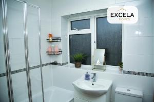 a white bathroom with a sink and a shower at Potter's Cove in Watford - Walk to the Studios in Leavesden Green