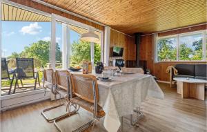 a dining room with a table and chairs and windows at Holiday Home Humlevænget Iii in Hejls