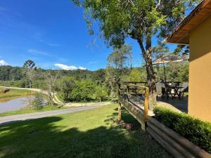 a house with a porch with a table and a tree at Cabanas Grande Passo in Quatro Barras