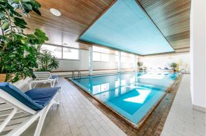 a large swimming pool with a large glass ceiling at Ferienwohnung Champfèr in St. Moritz