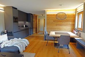 a kitchen and living room with a table and chairs at Ferienwohnung Champfèr in St. Moritz