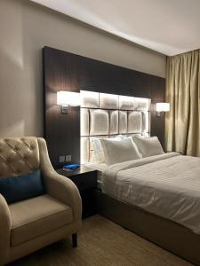 a hotel room with a bed and a chair at شقق رويال العلا الفندقية in AlUla