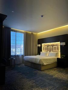 a bedroom with a large bed and a large window at شقق رويال العلا الفندقية in AlUla
