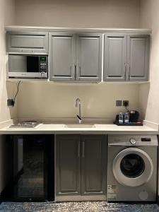 a kitchen with a sink and a microwave at شقق رويال العلا الفندقية in AlUla