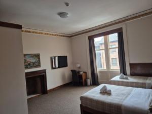 Ένα ή περισσότερα κρεβάτια σε δωμάτιο στο Douglas Hotel