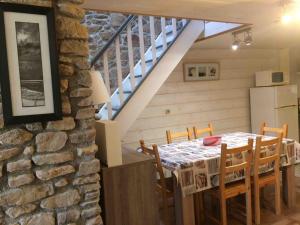 a dining room with a table and a stone wall at Gite bord de mer La Hague Port Racine in Saint-Germain-des-Vaux