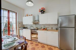 kuchnia z białymi szafkami i stołem w obiekcie Casa Maddalena al Mare 600m from sea - Happy rentals w mieście Marina di Pietrasanta