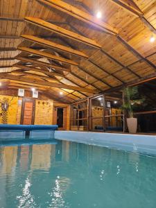 an indoor swimming pool with a wooden ceiling at Leśna Osada Szegdy in Szegdy