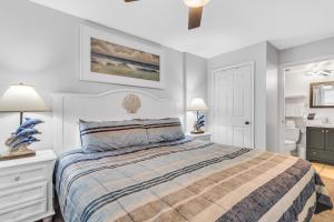 a bedroom with a bed and a bathroom at Royal Palms 907 in Gulf Shores
