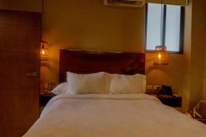 a bedroom with a large white bed with two pillows at Hotel Scappata in Progreso