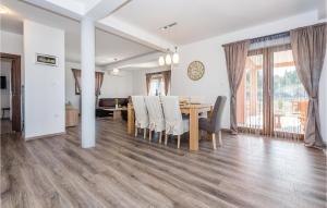 a dining room and living room with a table and chairs at Four-Bedroom Holiday Home In Bilice in Bilice