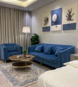a living room with a blue couch and a table at إستديو هادئ حي حطين قريب من البوليفارد in Riyadh