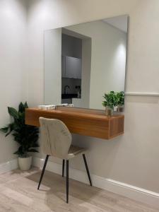 a mirror on a wall with a desk and a chair at إستديو هادئ حي حطين قريب من البوليفارد in Riyadh