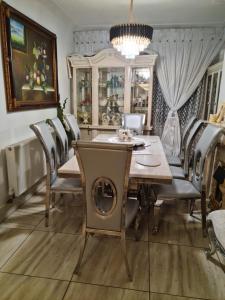 a dining room with a table and chairs and a chandelier at 669 London Road Wilmorton in Derby