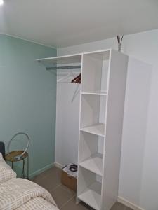 a white bookcase in a bedroom next to a bed at l'échappée verte in Le Mée-sur-Seine