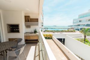 an apartment balcony with a view of the ocean at Conforto à beira-mar in Florianópolis +35 photos