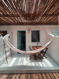 a hammock in a room with a table at Encanto Caraíva in Caraíva