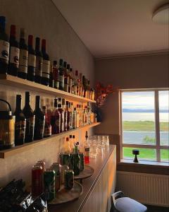 a bar with wine bottles and glasses on the wall at Ingimarsstaðir in Þórshöfn