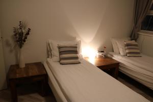a bedroom with two beds and a vase of flowers at Guesthouse Lyngholt in Þórshöfn