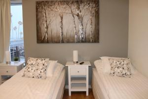 a bedroom with two beds and a table with a picture at Guesthouse Lyngholt in Þórshöfn