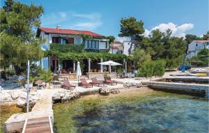 una casa con sillas y una piscina de agua en 2 Bedroom Stunning Home In Brodarica, en Brodarica