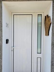 a door in a white wall with a window at Casa d´Avó in Fiais da Telha