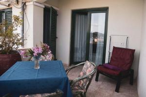 een tafel en stoelen met een vaas met bloemen op een patio bij Apartments Novis in Kali