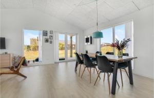 a dining room with a table and black chairs at 3 Bedroom Beautiful Home In Jerup in Jerup