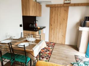 a kitchen with a table and chairs in a room at Logement proche Caen et plages in Colombelles