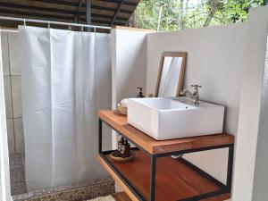 a bathroom with a sink and a mirror at Four Monkeys Eco Lodge - Jungle & Beach in Cabo Matapalo +62 photos