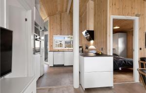 a kitchen with white cabinets and wooden walls at Four-Bedroom Holiday Home In Hadsund in Nørre Hurup