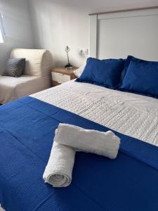 a white towel is laying on a blue bed at Costa Relax in Puerto de Mazarrón