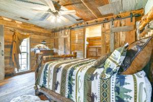 a bedroom with a bed in a room with wooden walls at half-Mi to Lake Cabin on 43 Acres in Shell Knob! in Shell Knob