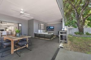 a patio with a table and chairs and a couch at Dalton Cottage - Charm & Convenience in Orange