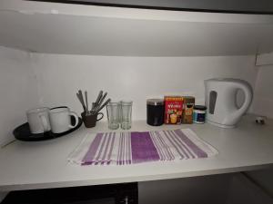 a counter with cups and utensils on a table at Guesthouse in Tilbury +19 photos