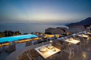a restaurant with a pool with tables and chairs at BASSA MAINA Villas & Suites in Areopolis